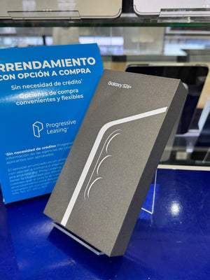 Samsung Galaxy S24+ smartphone box in dark gray packaging with a white curved stripe design, standing on a display stand on a blue counter next to a blue leasing offer card.