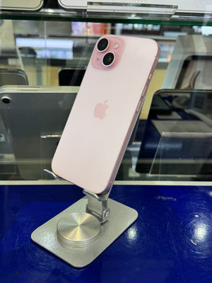 A light pink Apple iPhone 13 Pro displayed on a silver metal stand inside a retail store, with glass cases and other devices blurred in the background.