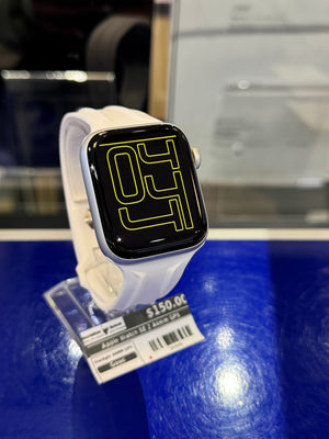 Smartwatch with a black screen displaying a logo, on a stand with a blue background.