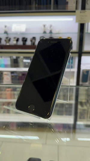 Black smartphone on a stand with a blurred store background