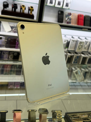 Gold iPad on display in a store with various phone cases in the background
