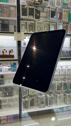 iPad displayed in a store setting with various phone cases in the background