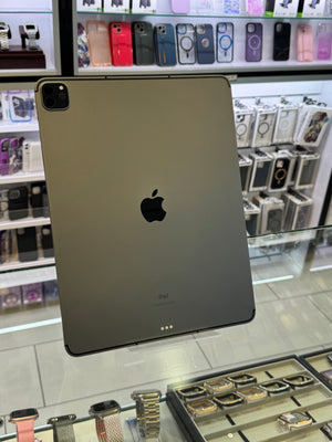 Back view of an Apple iPad with a store display of phone cases in the background.