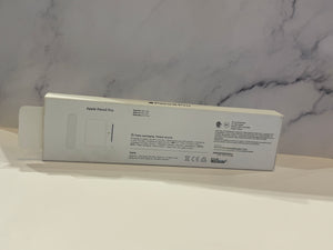 Apple Pencil Pro packaging box shown from the back, featuring product specifications and regulatory text on a white surface against a gray marble-patterned background.