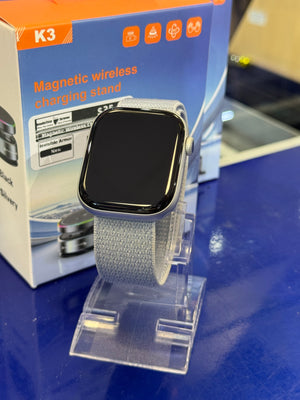 Smartwatch with gray band on a blue surface with packaging