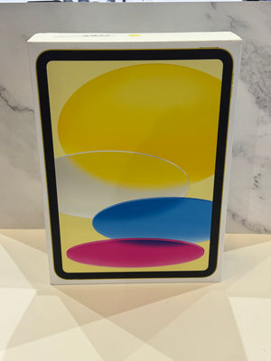 A white Apple iPad box standing upright on a light surface, with a colorful abstract screen graphic showing yellow, blue, and pink shapes.