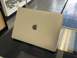 laptop with Apple logo on a reflective surface