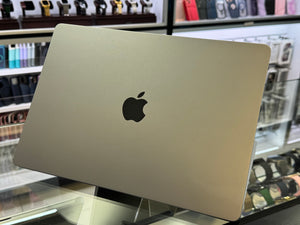 Silver laptop with Apple logo on a display stand in a store