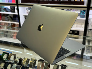MacBook Pro on display in a store with watches below
