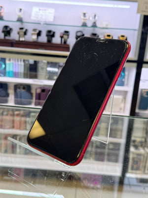 Red iPhone on a clear stand against a blurred store background