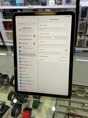 Tablet displaying battery health settings with a blurred store background