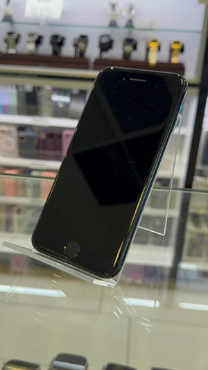 Black smartphone on a clear stand with a blurred store background
