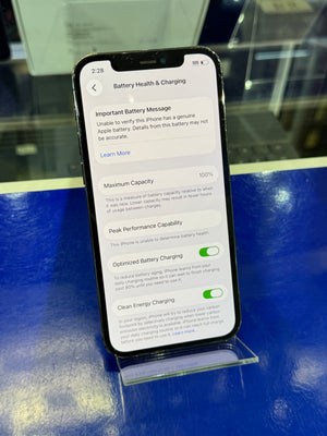 Smartphone displaying battery health and charging information on a blue surface