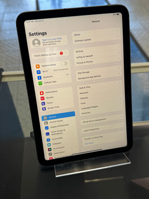 Tablet displaying a settings menu on a reflective surface