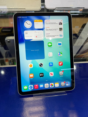 An iPad with a black bezel displaying its home screen, resting on a glossy blue surface.