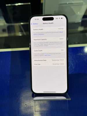 Smartphone displaying a battery health screen on a reflective surface with a blue background