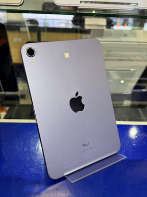 Back view of an Apple iPad on a blue surface with a blurred background