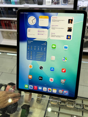Tablet displaying a home screen with various app icons in an indoor setting.