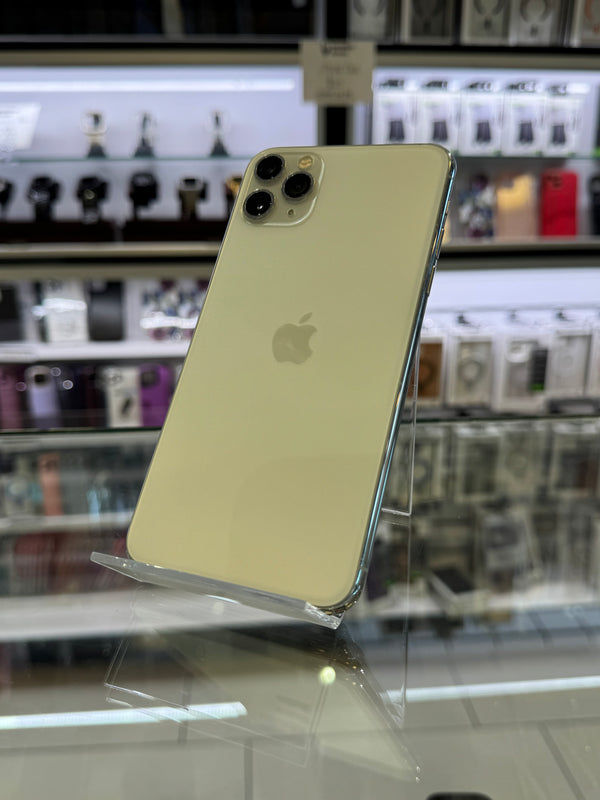A white iPhone Pro showing its back panel with the Apple logo, photographed inside a retail store with glass display cases in the background.