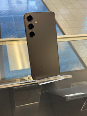 Black smartphone on a reflective surface with blurred background