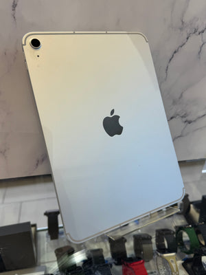 An Apple iPad with a silver back panel and silver bezel, shown from the back on a clear display stand in a retail setting.