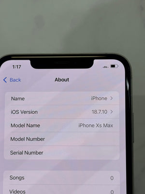 Close-up of an iPhone displaying the 'About' screen with device details including 'Name: iPhone', 'iOS Version: 18.7.