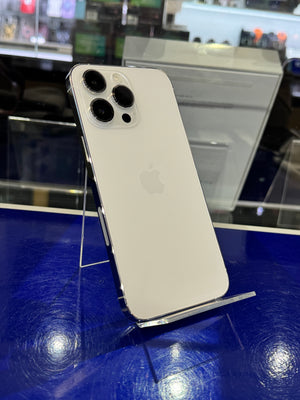 Silver iPhone 12 Pro Max on a stand with a blurred store background