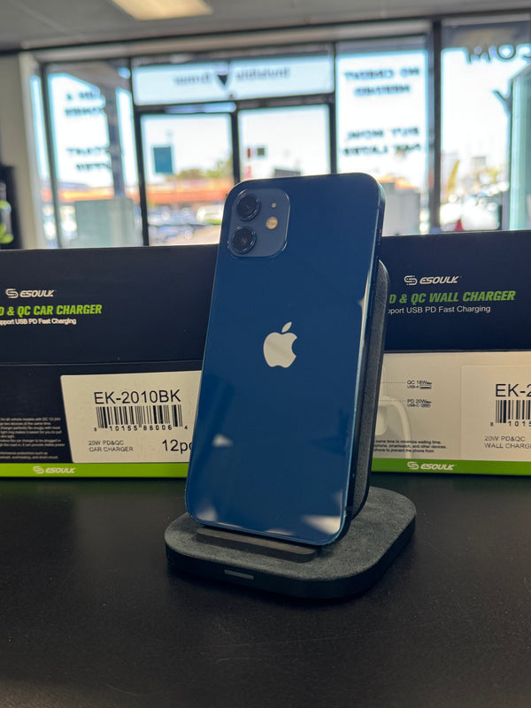 A blue Apple iPhone stands upright on a charging dock on a dark tabletop, with Esoulk product boxes in the blurred background.