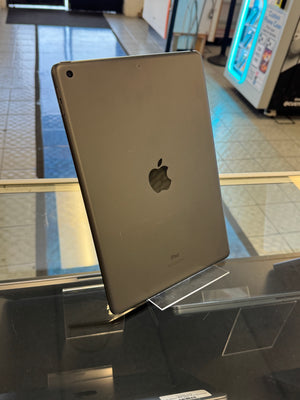 Silver Apple iPad on a glass surface with a store interior background
