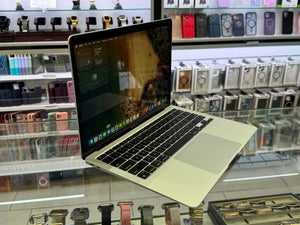 Laptop on display in a store with phone cases and watches in the background
