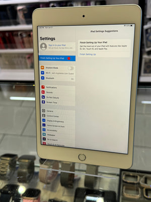 White iPad displaying settings screen on a reflective surface