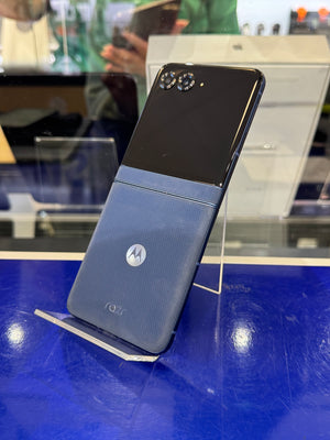Motorola phone on display with a blue stand in a store setting