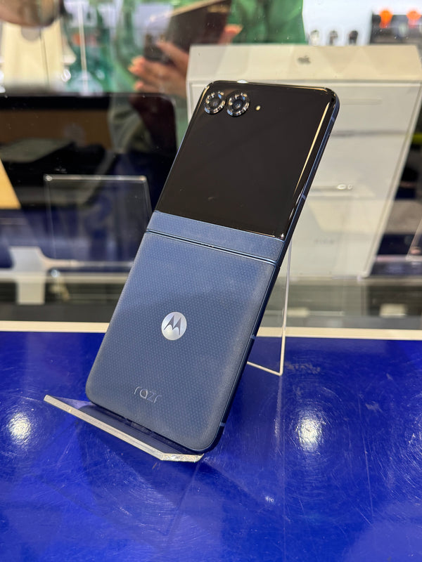 Motorola phone on display with a blue stand in a store setting
