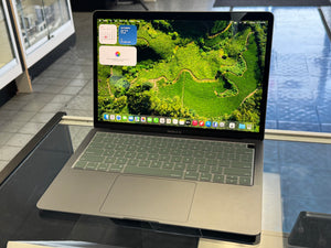 Laptop on a glass surface with a scenic display