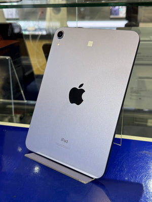 Silver iPad on display with an Apple logo on a blue surface