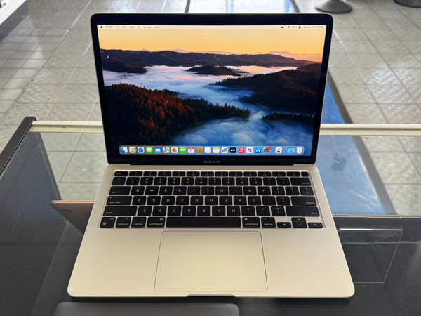 Laptop on a glass table with a scenic display