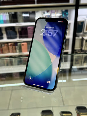 Smartphone with a reflective screen on a stand against a blurred indoor background