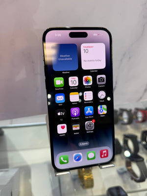 A black iPhone with a large screen displaying various colorful app icons, shown on a metal display stand in a retail setting with blurred watches in the background.