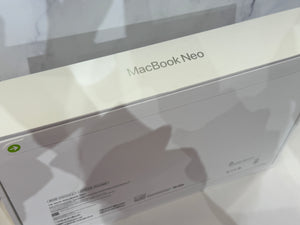 A close-up of a white Apple MacBook Neo product box, showing the 'MacBook Neo' text on the top surface and some printed specifications on the side.