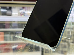 Smartphone held by a transparent stand against a blurred indoor background
