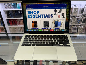 Laptop displaying a shopping website with a store in the background