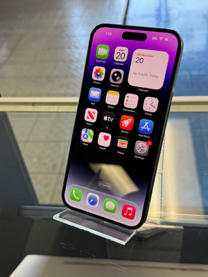 Smartphone with app icons displayed on a stand against a blurred indoor background