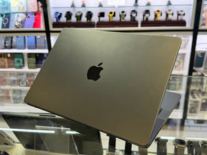 Silver Apple laptop on a glass surface with shelves in the background
