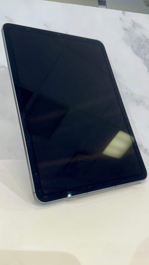 A black tablet with rounded corners, shown standing at an angle on a white surface with a light gray marble-patterned background.