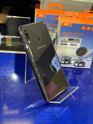 Black Samsung phone on a stand with a K3 magnetic wireless charging stand in the background