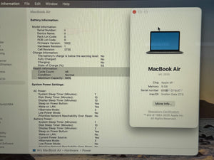 A close-up of a MacBook Air computer screen showing battery and system information, with a second MacBook Air window open on the right. The image is taken in a real environment with a blurred desk or room background.