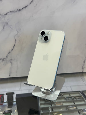 An Apple iPhone with a light off-white back and silver camera lenses, displayed on a metallic stand in front of a white marble-patterned wall.