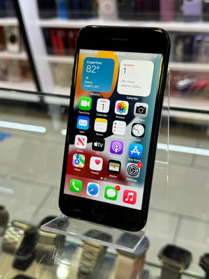 Smartphone with app icons displayed on a clear stand against a blurred background