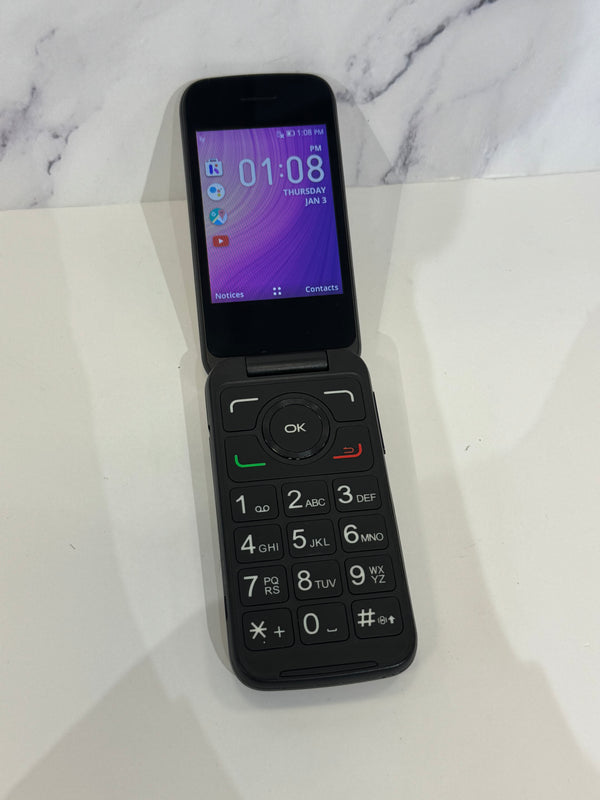 An open flip phone with a purple screen and dark keypad resting on a white background