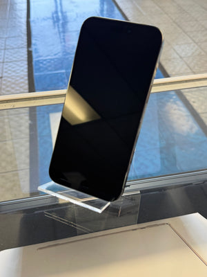 Black smartphone held by a hand with a reflective surface background
